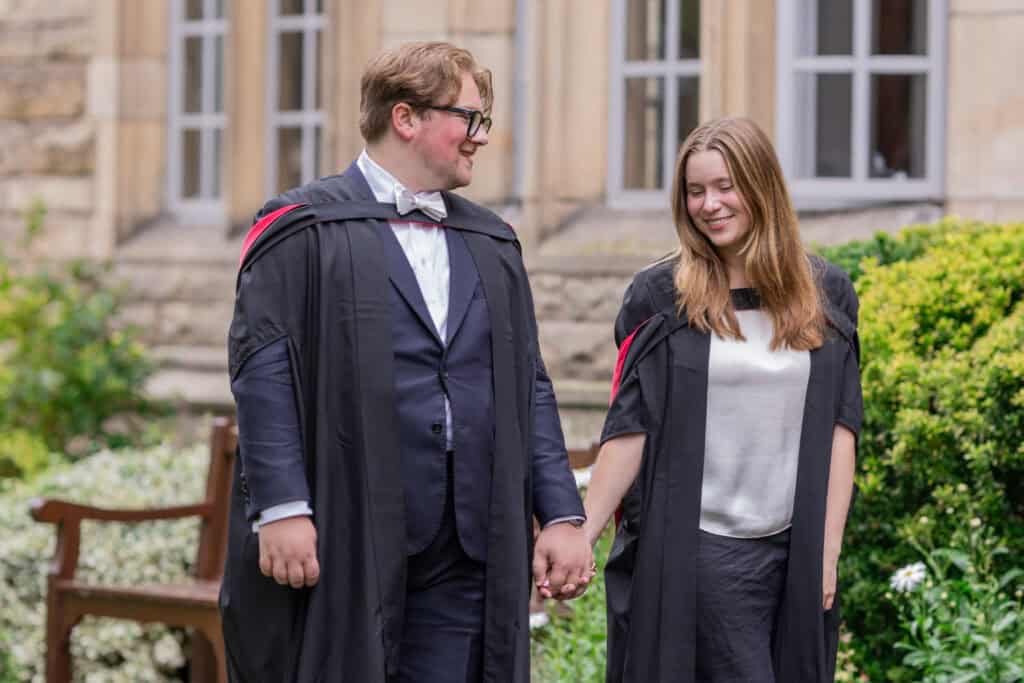 Graduates holding hands in university garden