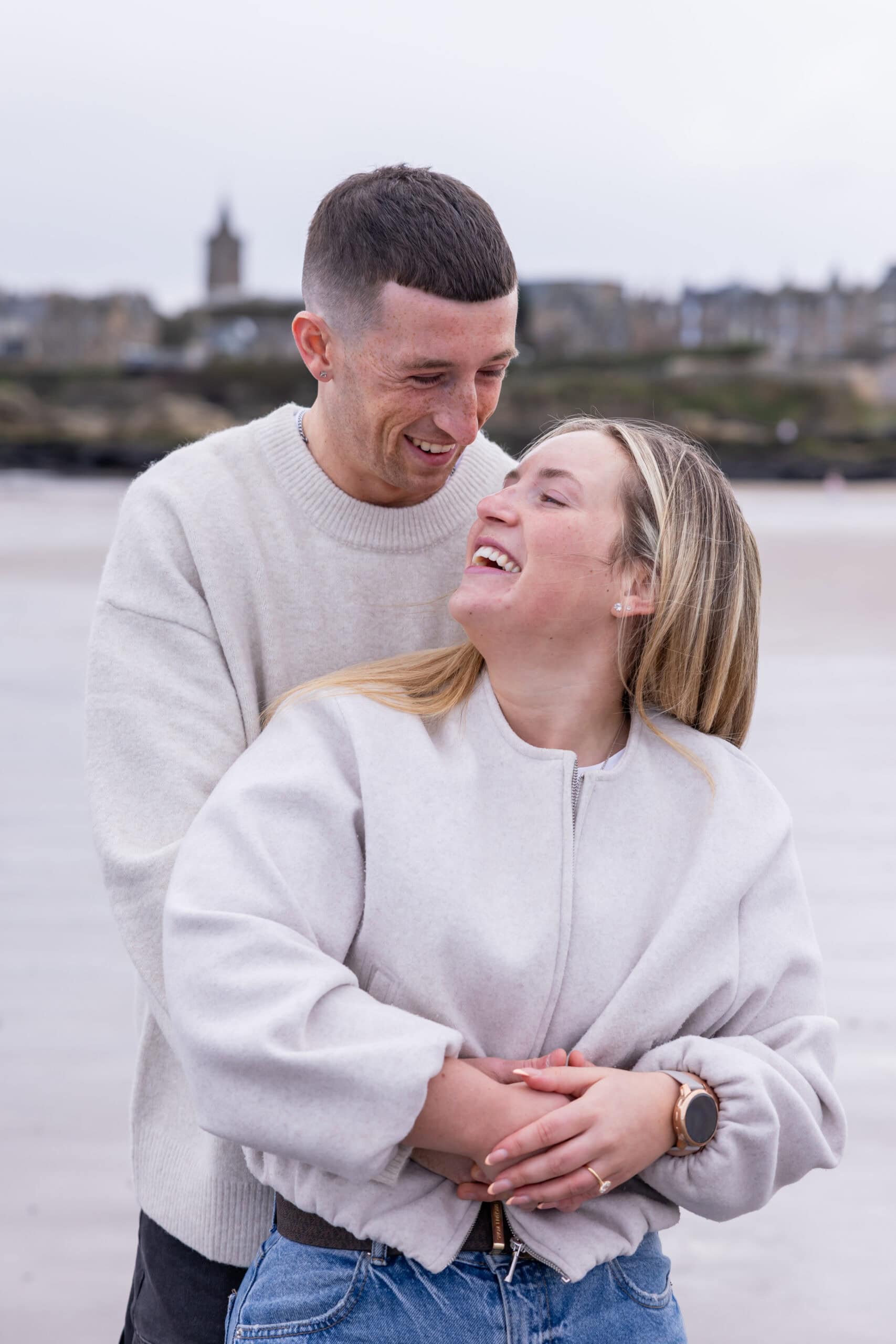 Couple laughing on a beach.
