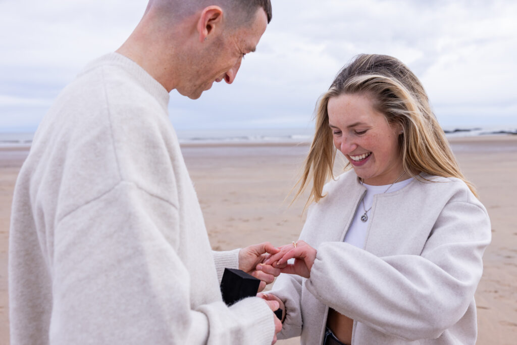 Couple exchanging rings on a beach.