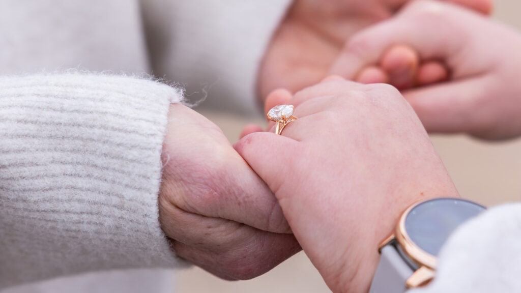 Hands holding with engagement ring