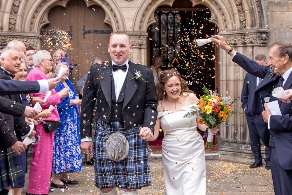 Bride and groom showered with confetti outside church