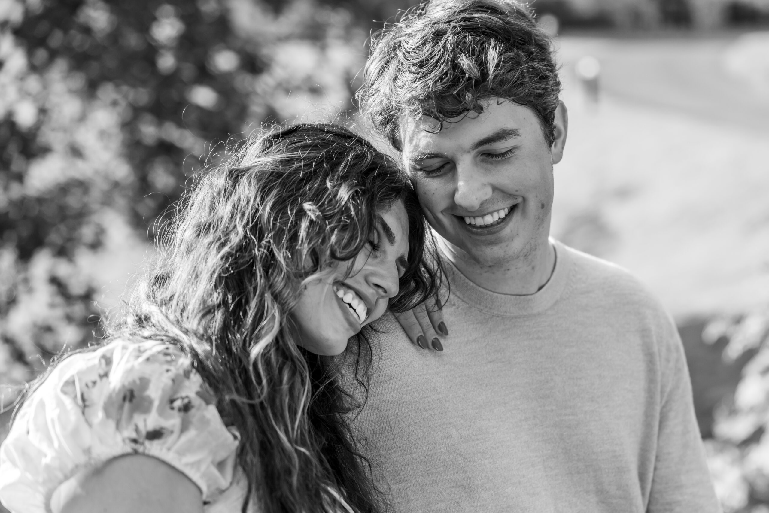 A couple smiling and embracing outdoors