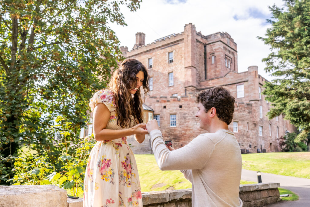 Man proposes to woman outside a historic castle