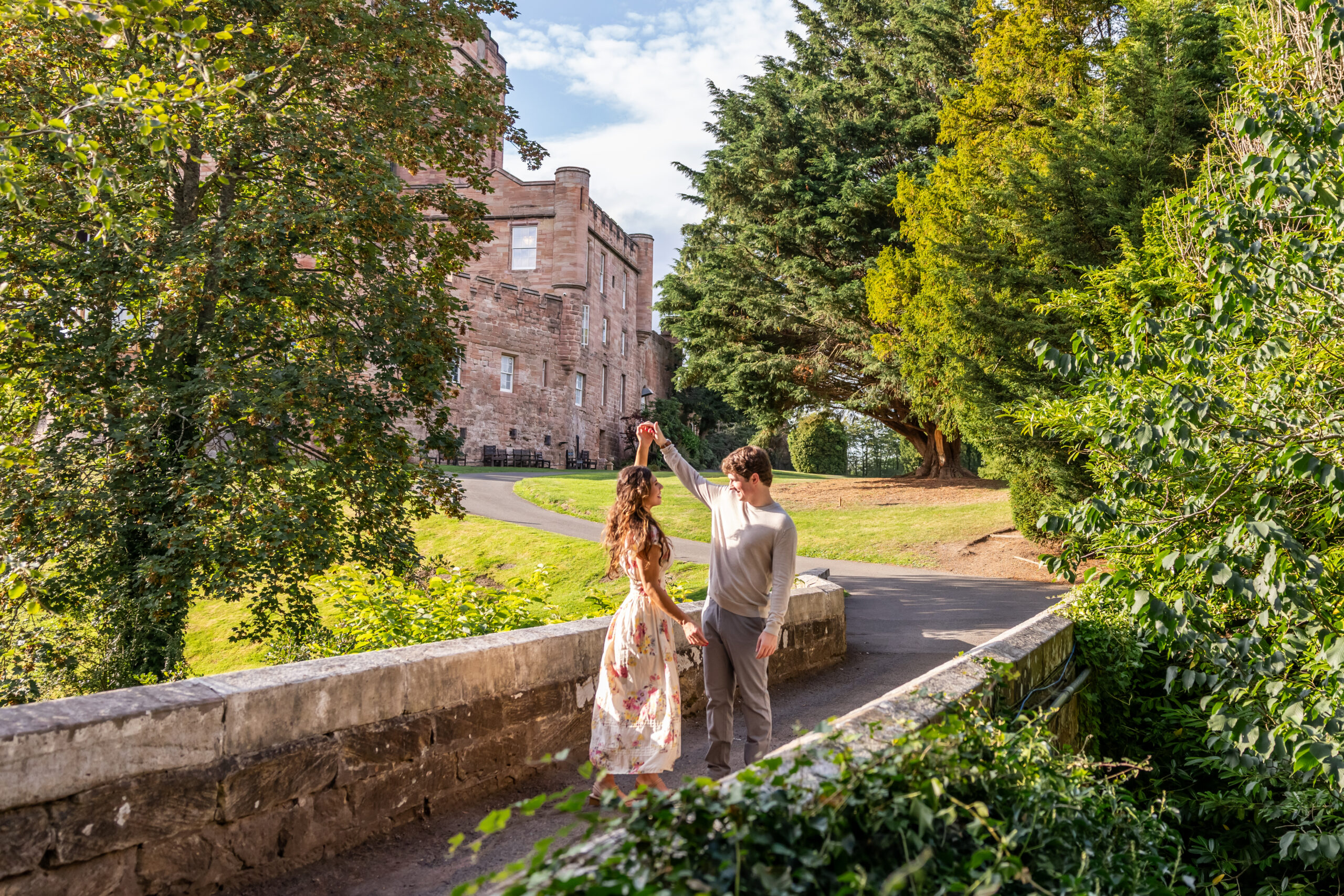 Couple dancing beside Dalhousie Castle in leafy gardens